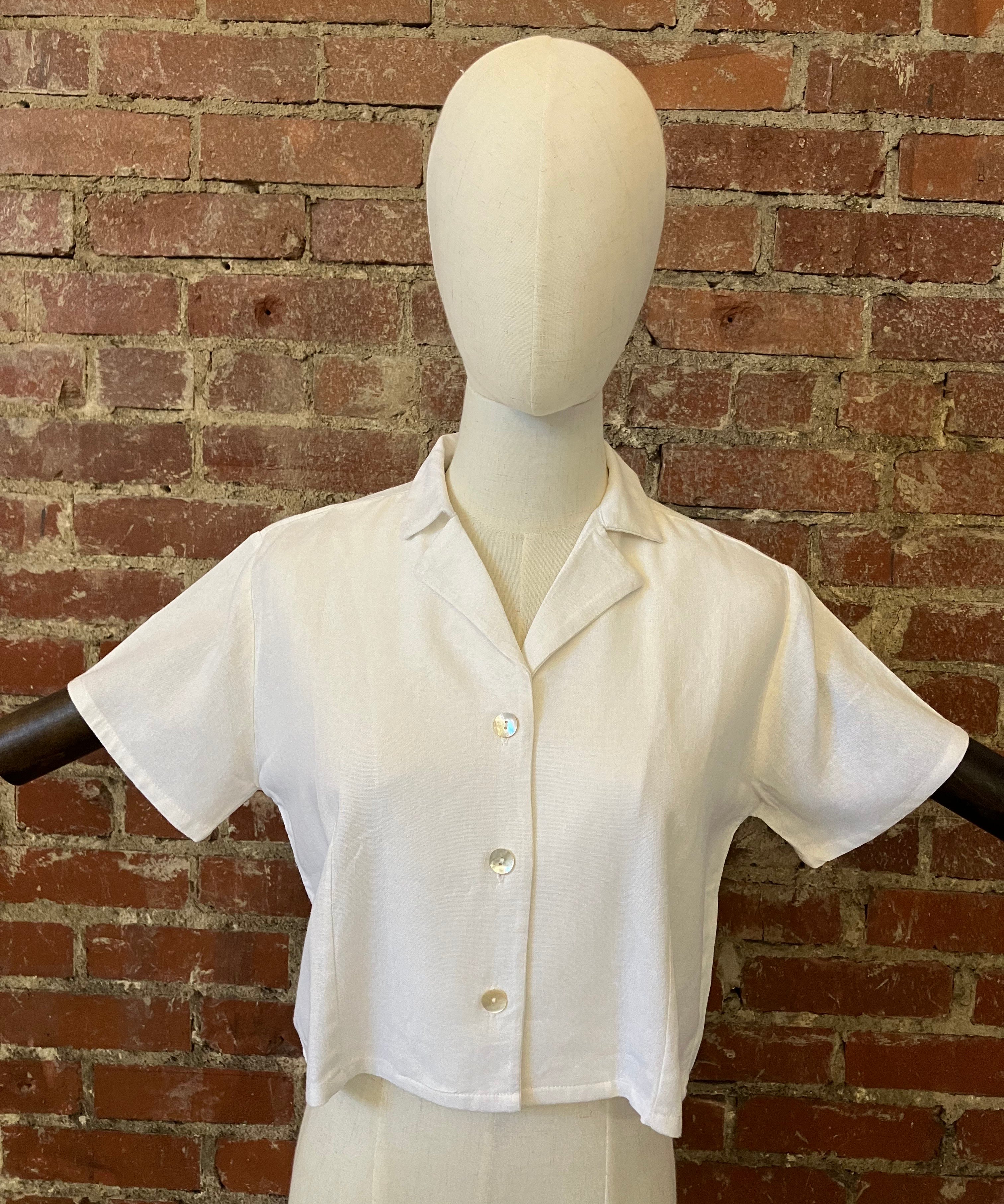 White shirt on a mannequin against a brick wall