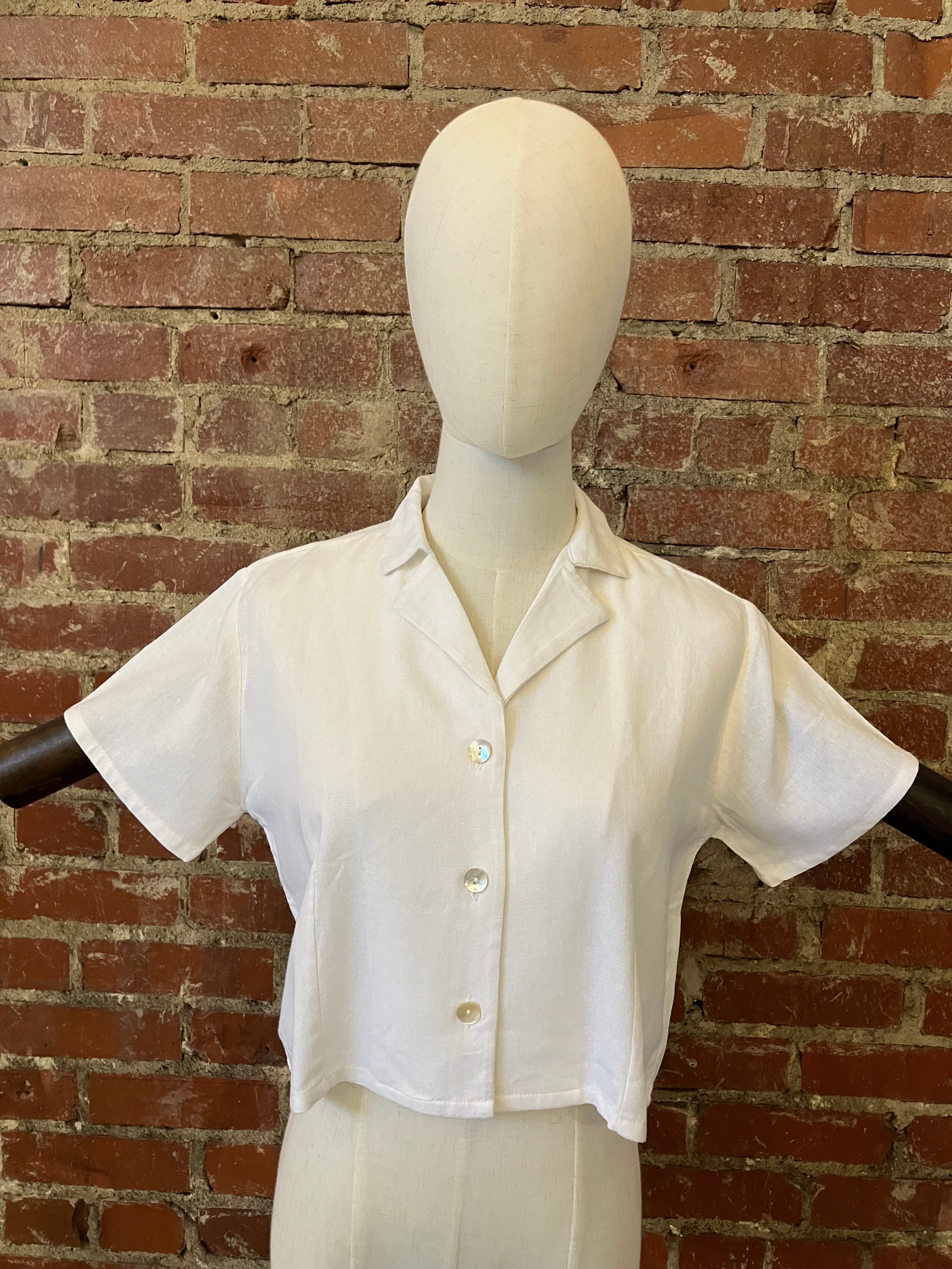 White shirt on a mannequin against a brick wall