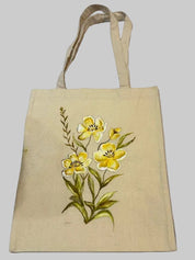Beige tote bag with yellow floral design on a light background